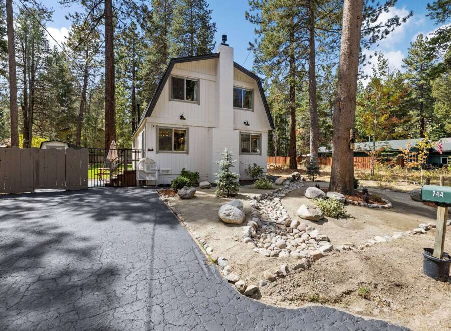 Charming A-frame home nestled among tall pine trees, offering a serene mountain retreat.