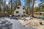 Charming A-frame home nestled among tall pine trees, offering a serene mountain retreat.