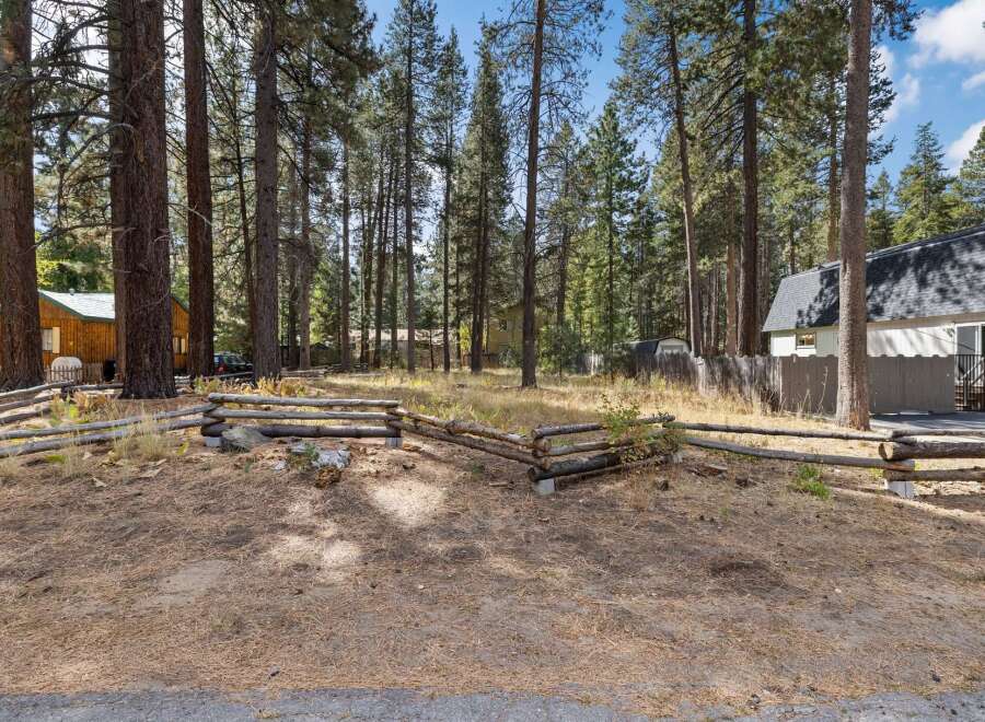 Nestled among tall pine trees, this property offers a serene and private setting.