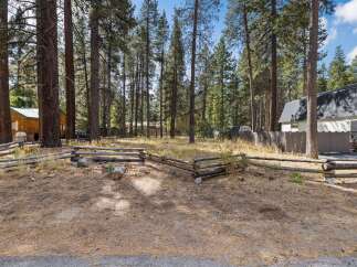 Nestled among tall pine trees, this property offers a serene and private setting.