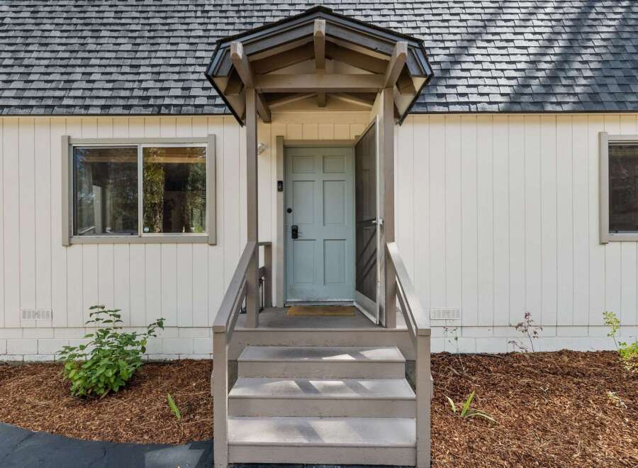 Charming home featuring a welcoming light blue front door, perfect for greeting guests.