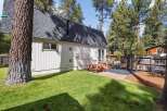 Enjoy outdoor living in this charming backyard featuring a picnic table and umbrella, perfect for al fresco dining.