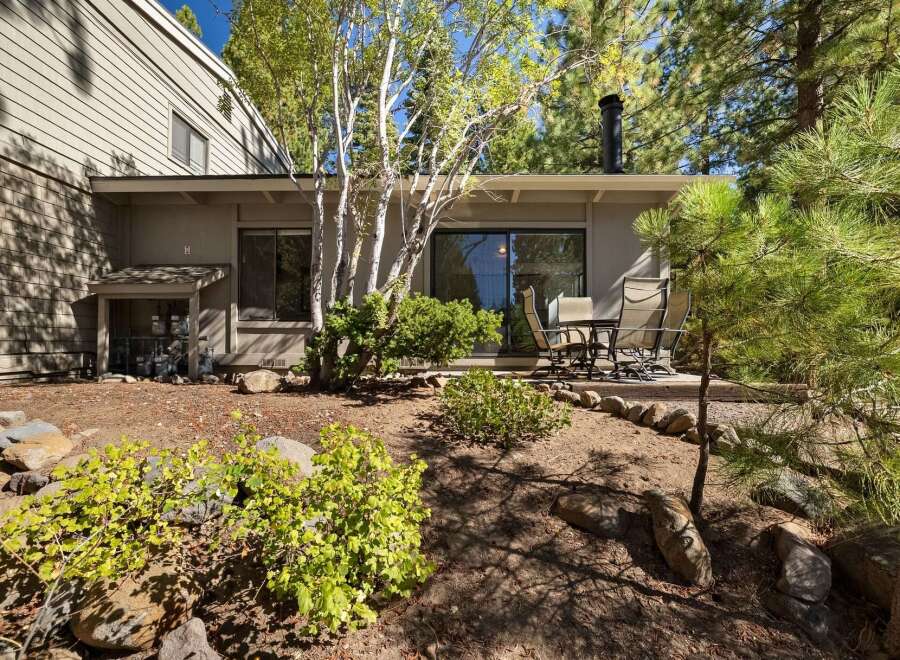 Enjoy outdoor living on this charming patio, perfect for al fresco dining or morning coffee surrounded by mature trees.