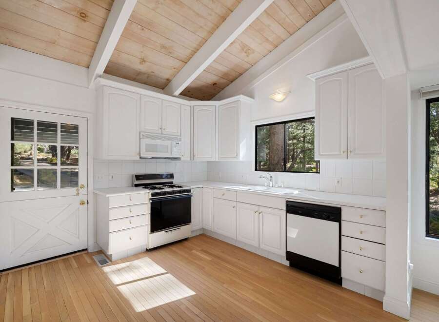 Charming kitchen featuring white cabinetry, a gas range, and a dishwasher, perfect for home chefs.
