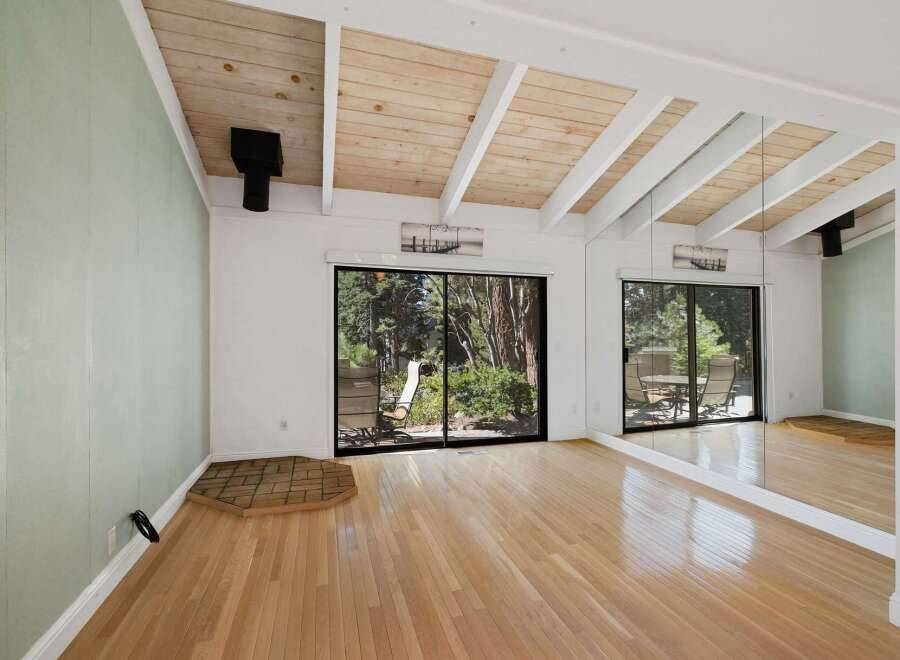 Experience the charm of this spacious living area, featuring a vaulted wood-paneled ceiling with exposed beams that add architectural interest.