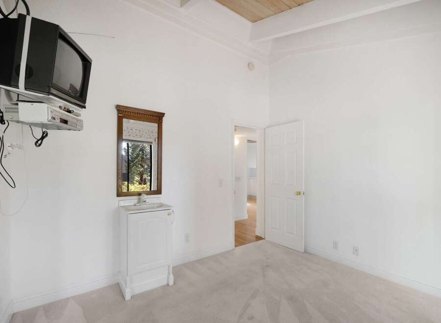 This bedroom offers a unique setup with a wall-mounted television and entertainment system, perfect for unwinding.