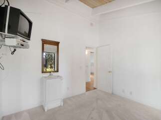 This bedroom offers a unique setup with a wall-mounted television and entertainment system, perfect for unwinding.