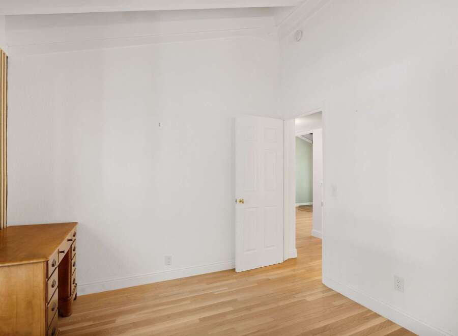 This bright and airy room features a charming wooden desk, perfect for a home office setup.