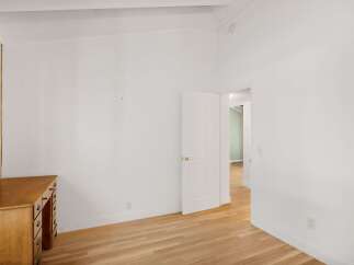 This bright and airy room features a charming wooden desk, perfect for a home office setup.