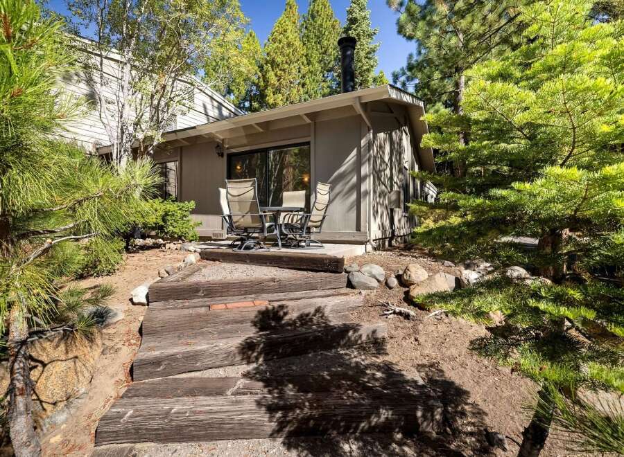 Enjoy outdoor living with this charming patio area, perfect for al fresco dining or morning coffee surrounded by mature trees.