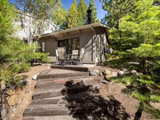 Enjoy outdoor living with this charming patio area, perfect for al fresco dining or morning coffee surrounded by mature trees.