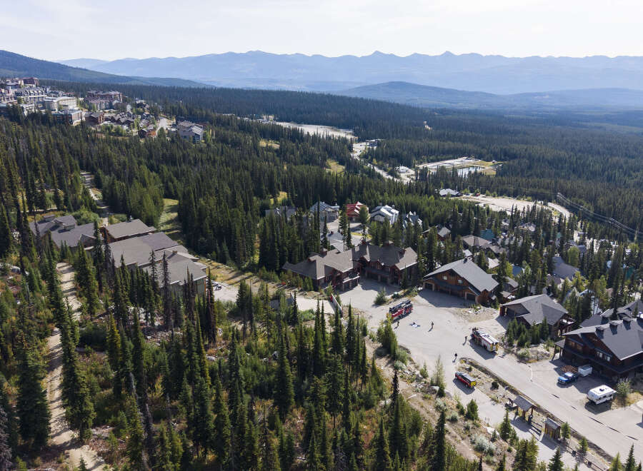 Discover this stunning mountain retreat nestled amidst a dense evergreen forest, offering breathtaking panoramic views of rolling hills and distant peaks.