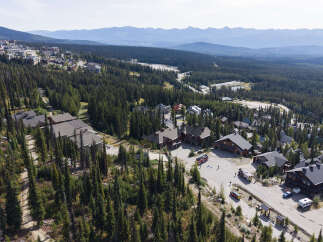 Discover this stunning mountain retreat nestled amidst a dense evergreen forest, offering breathtaking panoramic views of rolling hills and distant peaks.