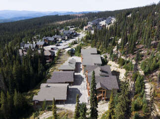 Discover this stunning mountain retreat nestled amidst a dense evergreen forest, offering breathtaking panoramic views of rolling hills and distant mountains.