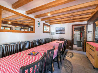 Experience a charming dining area perfect for gatherings, featuring a long table draped in a classic red and white checkered tablecloth.