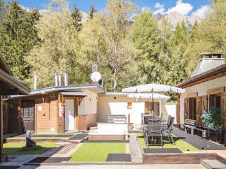 Experience tranquility in this mountain retreat featuring a relaxing hot tub and an outdoor dining area perfect for enjoying the serene surroundings.