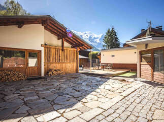 Experience the charm of this mountain retreat, featuring a rustic courtyard paved with natural stone and a cozy outdoor seating area.