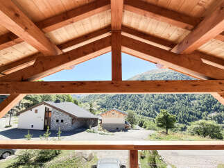 Experience the charm of mountain living with this stunning property, featuring a modern chalet design nestled amidst a lush, forested landscape.