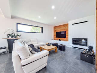 Experience modern living in this stylish living room, featuring a sleek white leather sectional sofa perfect for relaxation.