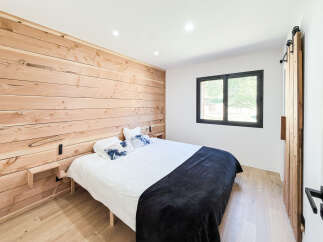 Experience rustic charm in this inviting bedroom, featuring a stunning natural wood accent wall that adds warmth and character.