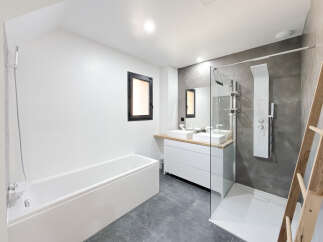 Experience modern luxury in this stunning bathroom featuring a deep soaking tub and a spacious walk-in shower with a rainfall showerhead.