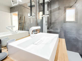 Experience modern luxury in this stunning bathroom featuring a sleek, minimalist white sink and a contemporary faucet.