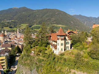 Discover this charming villa nestled on a hillside, offering breathtaking panoramic views of the surrounding mountains and the picturesque town below.