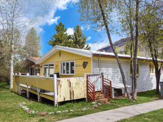Charming yellow home with a spacious deck, perfect for outdoor living and entertaining.