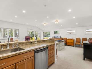 This spacious basement features a well-equipped kitchen area with a granite countertop, stainless steel dishwasher, and ample cabinet space.
