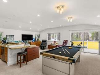 This versatile recreational space features a full-size pool table, perfect for hosting game nights.