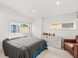 Discover this inviting bedroom featuring a comfortable bed with a grey quilted comforter and a bright blue accent.