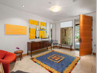 Step into this inviting entryway featuring a vibrant abstract art collection and a striking wooden door.