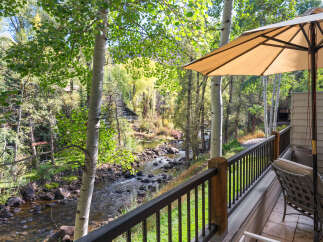 Enjoy serene mountain living with this stunning property offering a private balcony overlooking a picturesque river and lush forest.