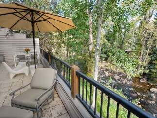 Enjoy serene mountain living on this charming deck overlooking a babbling creek and lush forest.