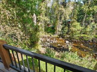Experience serene living with this stunning property featuring a picturesque stream flowing through lush, mature trees.