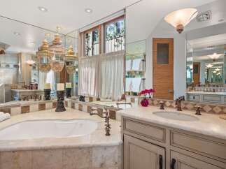 Indulge in luxury with this stunning bathroom featuring a deep soaking tub and a spacious vanity with dual sinks.
