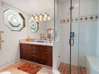 This spacious bathroom features a double vanity with rich wood cabinetry and a large mirror, perfect for busy mornings.
