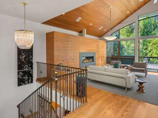 Experience luxury living in this stunning home featuring a grand living area with a modern fireplace and floor-to-ceiling windows offering breathtaking mountain views.