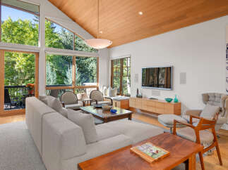 Experience luxurious living in this stunning mountain retreat, featuring a spacious living area with soaring vaulted ceilings and expansive windows that flood the space with natural light.
