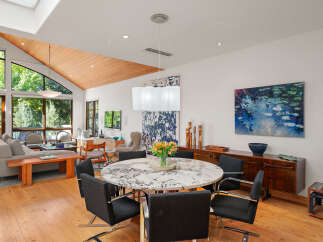 Experience luxurious open-concept living with soaring vaulted ceilings and abundant natural light pouring through expansive windows.