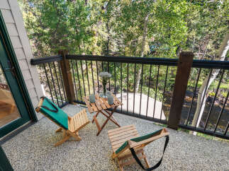 Enjoy your morning coffee or evening drink on this charming balcony overlooking a serene natural landscape.