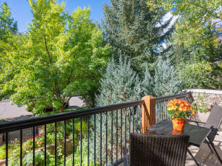 Enjoy your morning coffee on this charming balcony, surrounded by lush greenery and mature trees.