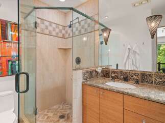 Experience luxury in this stunning bathroom featuring a spacious glass-enclosed shower with elegant tilework.