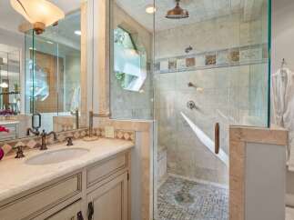 Experience luxury in this stunning bathroom featuring a spacious glass-enclosed shower with multiple showerheads and elegant tilework.