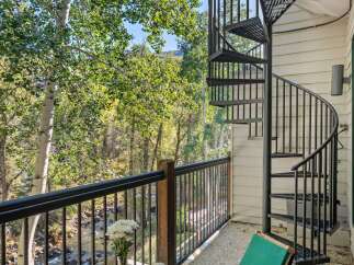 Enjoy breathtaking views from this charming balcony overlooking a serene river and lush greenery.