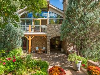 Experience the charm of this mountain home, featuring a stunning stone facade and a grand arched entryway.