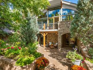 Experience luxurious mountain living with this stunning property, featuring a multi-level stone exterior and expansive windows that capture breathtaking natural light.