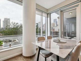 Experience urban living with this stunning dining area, featuring a sleek marble-top table and comfortable upholstered chairs.