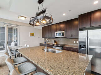Experience modern living in this stunning kitchen featuring rich, dark wood cabinetry and a spacious granite island perfect for entertaining.