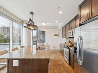 Experience modern urban living in this stunning kitchen featuring granite countertops and rich dark wood cabinetry.
